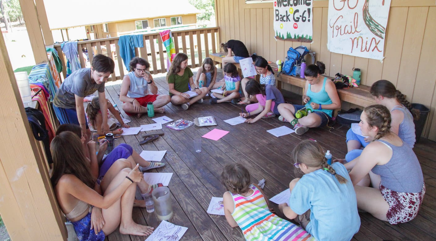 Campers sitting in circle playing games in bunk