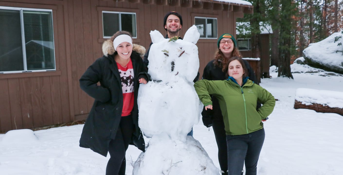 Teens building a snowman for Teen Winter Retreat