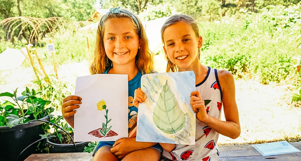 Girls holding nature drawings