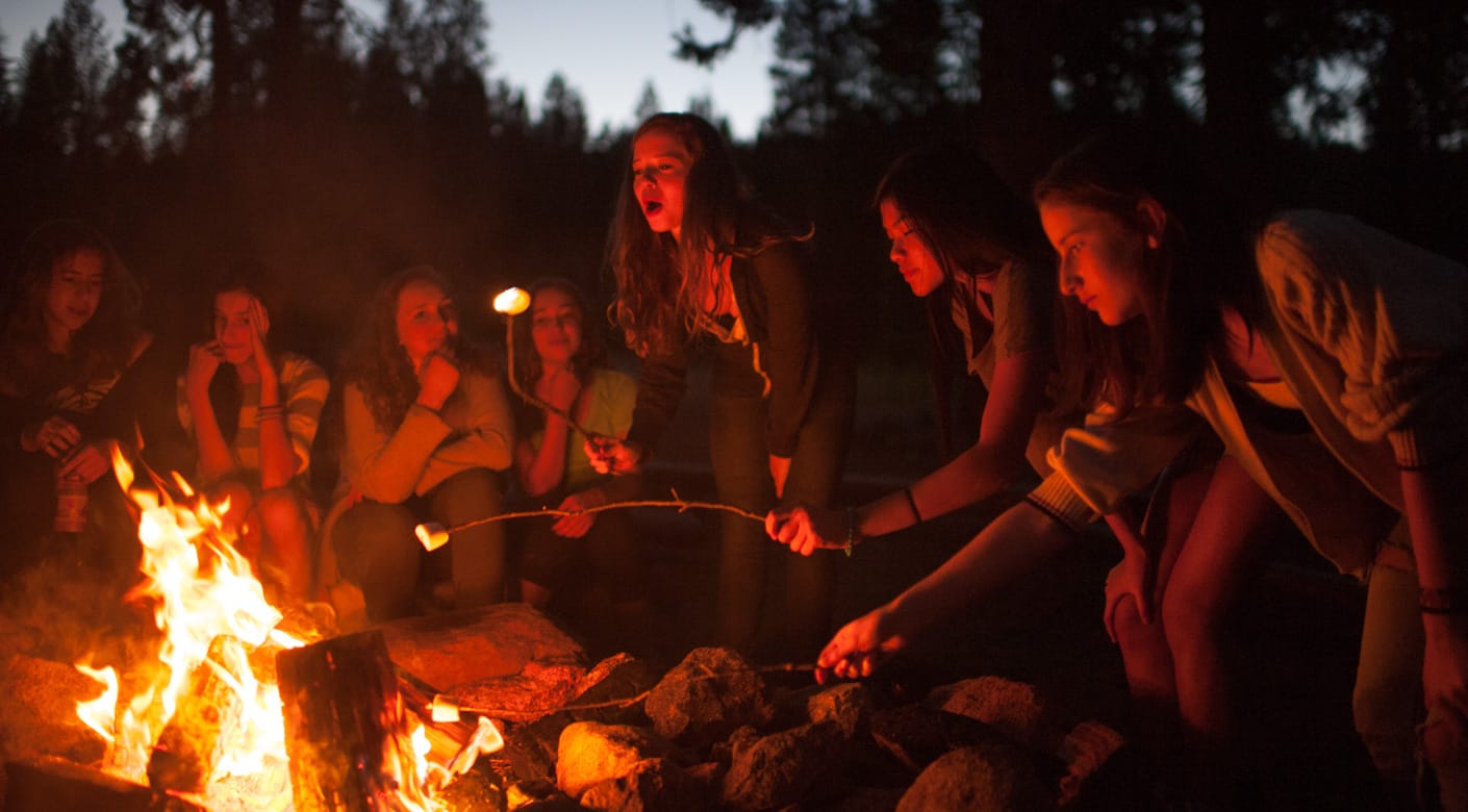 Counselors in training at a campfire