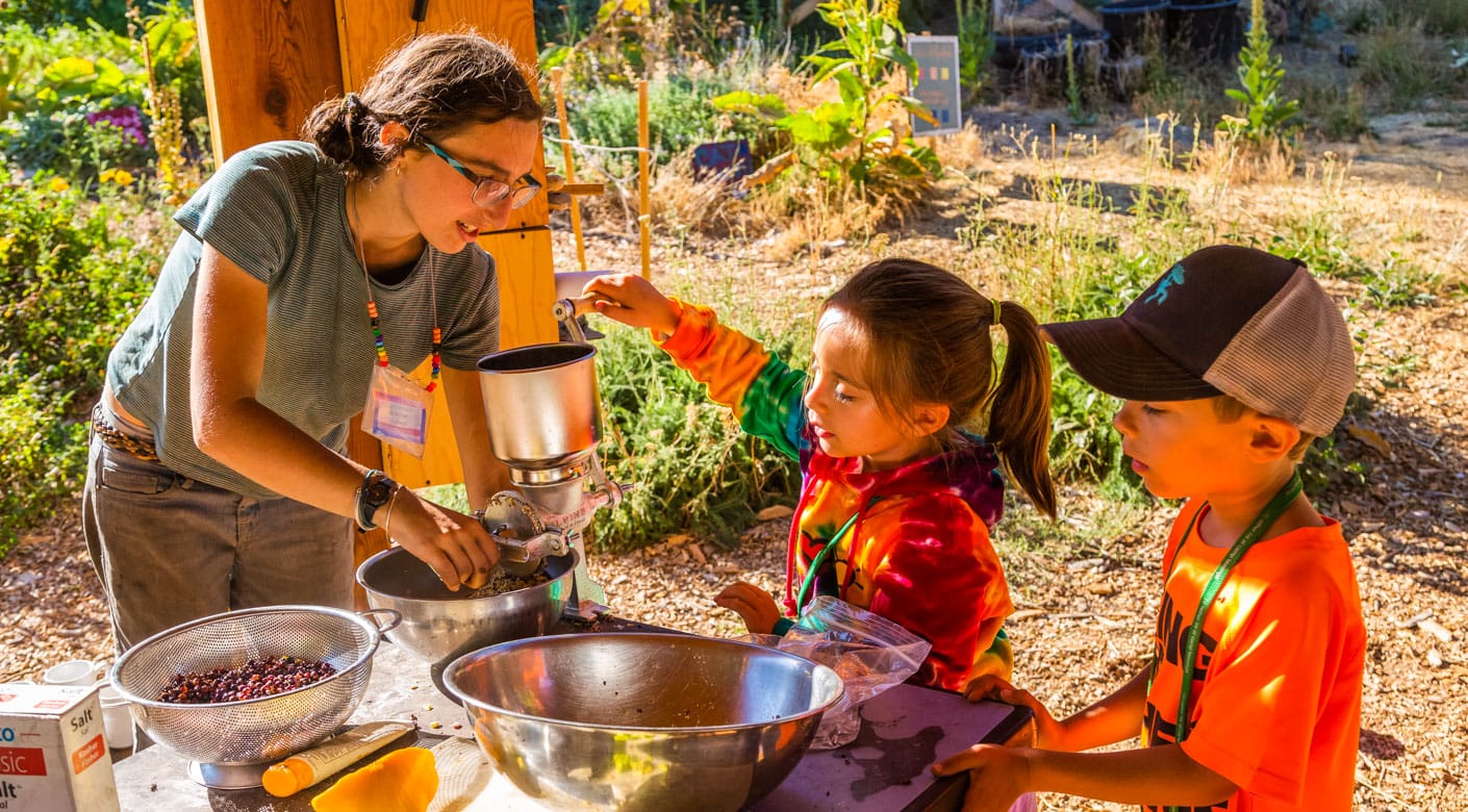 Staff and kids cooking outdoors for the Family Camp program