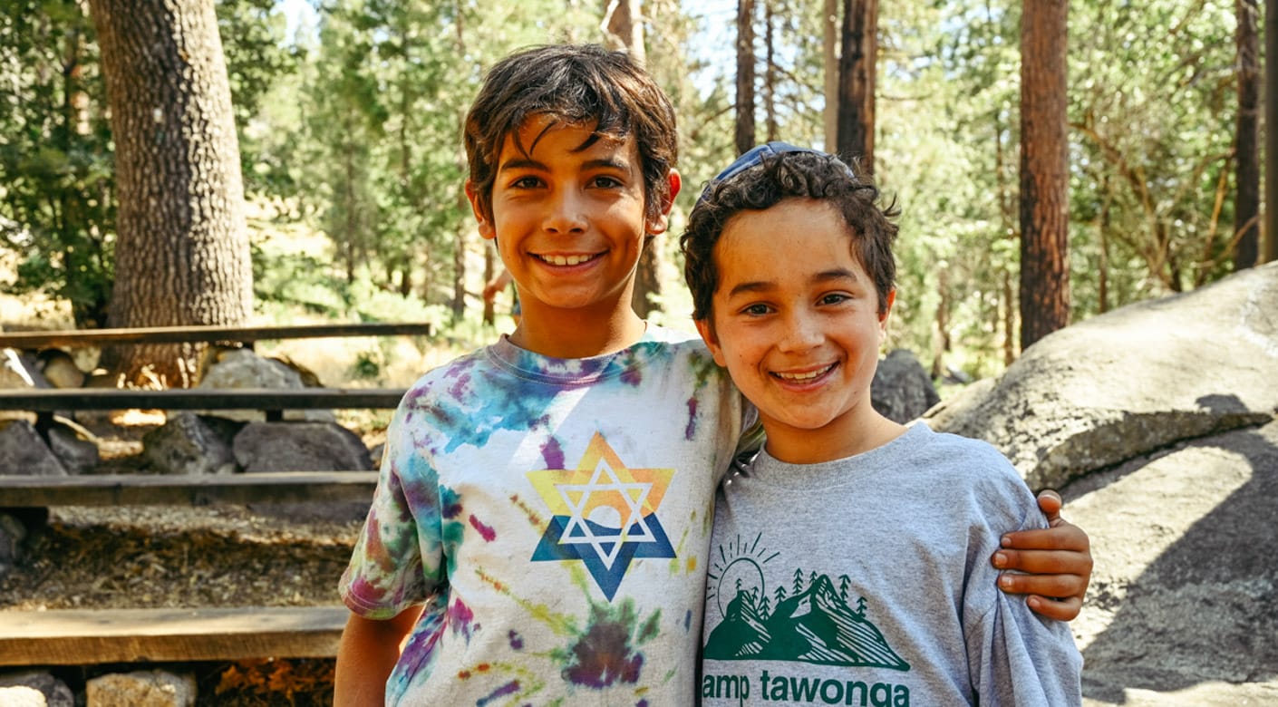 Two young campers smiling outside