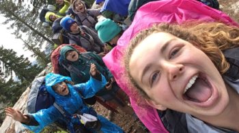 Teens taking a group selfie with backpacks on at the Women of the Wild quest
