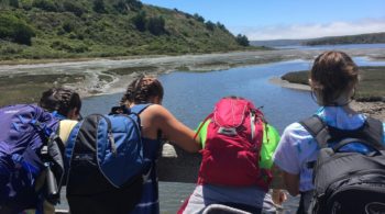Teens hiking and admiring view of water on the Women of the Wild quest